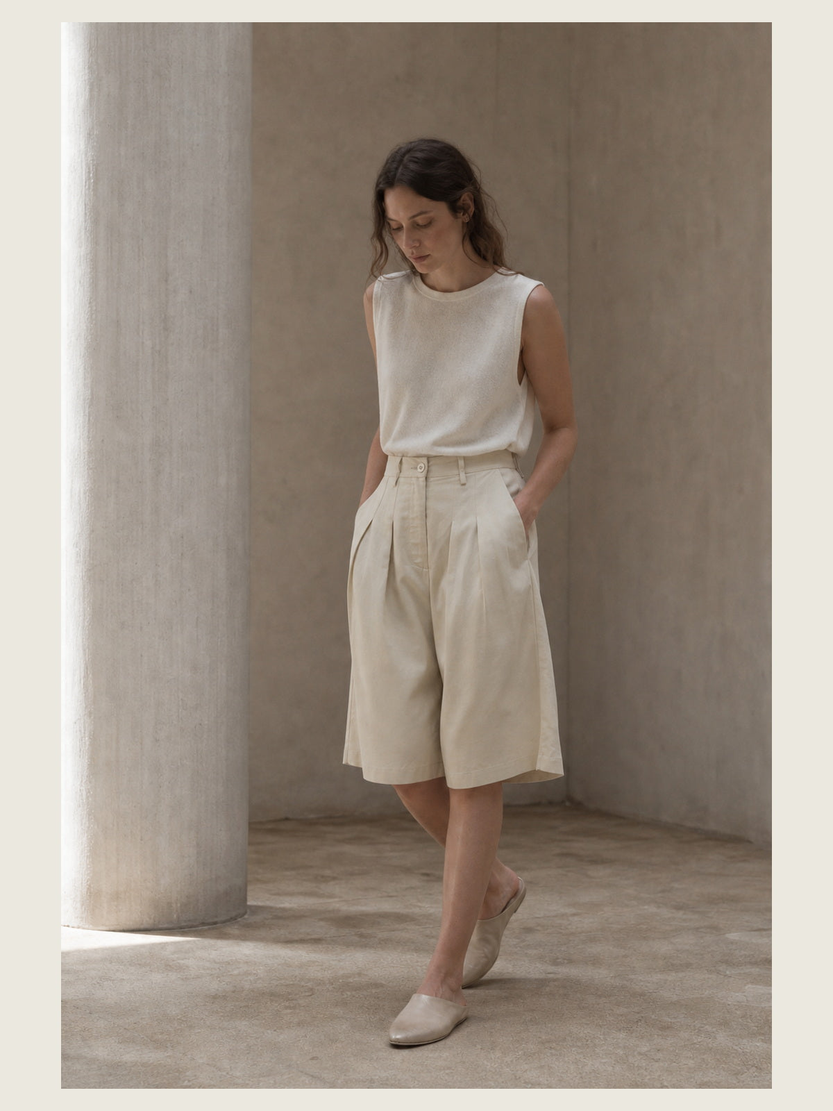 תמונת אווירה עריכתית של INN7 בסביבת טיח עבור Pleated Bermuda Shorts — NOSTRA SANTISSIMA